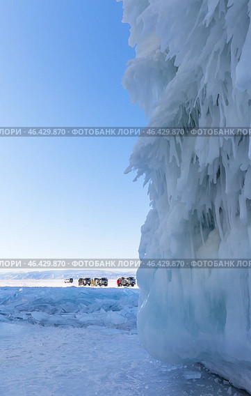 LAKE BAIKAL, OLKHON ISLAND, IRKUTSK REGION, RUSSIA -  February 22, 2025: Groups of tourists come to famous Cape Sagan-Khushun in SUVs to admire unusual icicles and beautiful ice crust on rocks. Редакционное фото, фотограф Виктория Катьянова / Фотобанк Лори