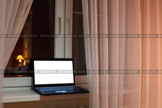 Laptop with cutout screen of monitor laying on windowsill at evening time in room. Стоковое фото, фотограф Кекяляйнен Андрей / Фотобанк Лори