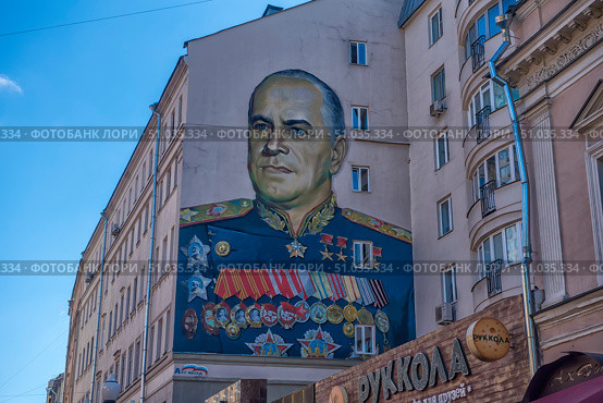 Large wall graffiti in Moscow with a portrait of Soviet commander Georgy Zhukov, made on the facade of a residential building. Zhukov is depicted in a ceremonial military uniform with numerous orders and medals. Bright and detailed street art is dedicated to the memory of the outstanding marshal of the Great Patriotic War. (2018 год). Стоковое фото, фотограф Анна Кривицкая / Фотобанк Лори