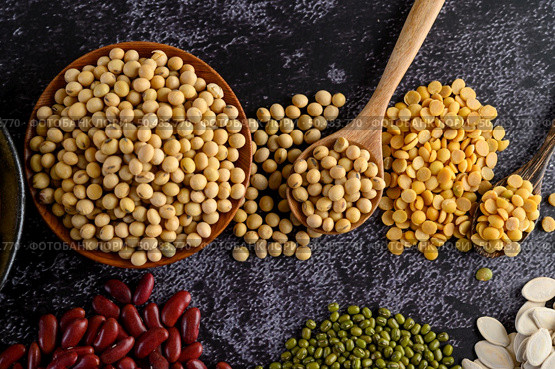 Legumes, and beans assortment on the black cement floor. Top view. Стоковое фото, агентство Ingram Publishing / Фотобанк Лори