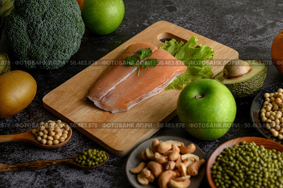 legumes, fruit, and Salmon fish pieces on a wooden chopping board. Стоковое фото, агентство Ingram Publishing / Фотобанк Лори