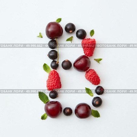 Letter B english alphabet in the form of a pattern of natural organic berries - ripe fresh raspberry, black currant, cherry, green mint leaf isolated on a white background. Flat lay.. Flat lay pattern of letter B english alphabet from natural ripe berries - black currant, cherries, raspberry, mint leaf isolated on a white background. Стоковое фото, агентство Ingram Publishing / Фотобанк Лори