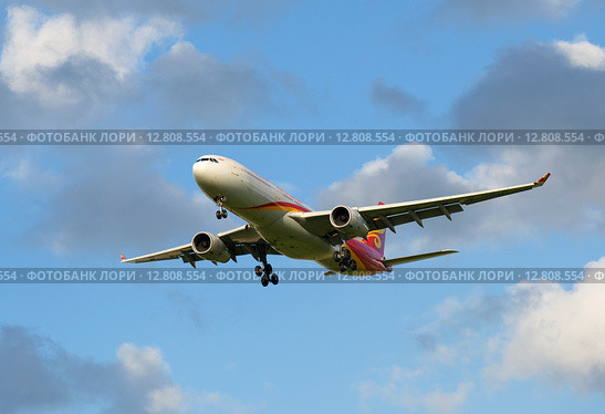 Летящий сквозь облака Airbus A330-343 (B-5910) авиакомпании Hainan Airlines (2015 год). Редакционное фото, фотограф Виктор Карасев / Фотобанк Лори