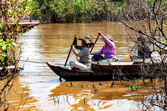 Life on Water at Tonle Sap Lake Shows Cambodian Women Traveling on a Boat (2014 год). Редакционное фото, фотограф Aleksandr Golubev / Фотобанк Лори