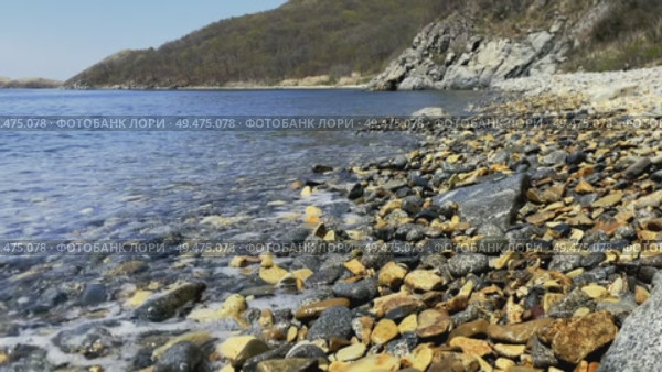 Light foamy wave breaks on the pebble shore. High quality 4k footage. Редакционное видео, видеограф Кирилл Зотов / Фотобанк Лори