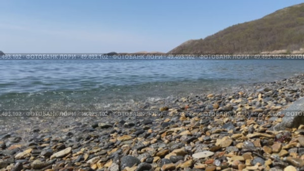 Light wave of surf on pebble shore. Splashes of sea foam create soothing noise. Стоковое видео, видеограф Кирилл Зотов / Фотобанк Лори