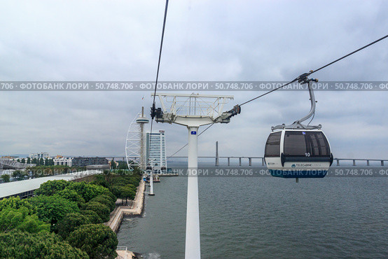Lisbon, Portugal May 22. 2018 Telecabine Lisboa at Park of Nations Parque das Nacoes. Cable car in the modern district of Lisbon over the Tagus river. Vasco da Gama tower and bridge. Редакционное фото, фотограф Вера Федорова / Фотобанк Лори