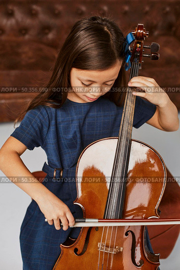 little cute girl learning how play cello. Стоковое фото, агентство Ingram Publishing / Фотобанк Лори