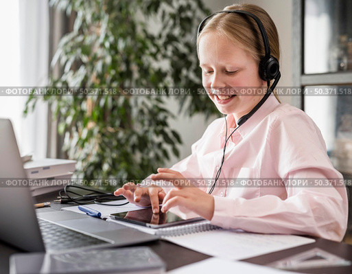 little girl participating online class while using tablet. Стоковое фото, агентство Ingram Publishing / Фотобанк Лори