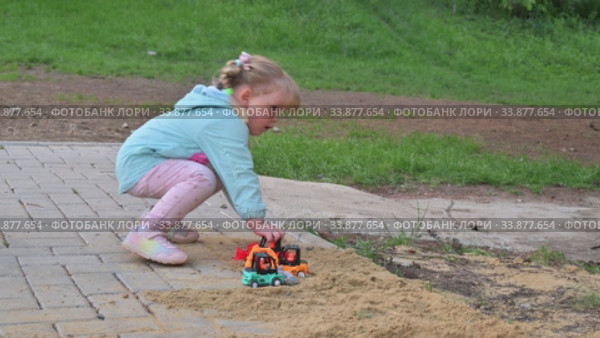 Little girl playing with toy cars in sandbox. Редакционное видео, видеограф Сергей Старуш / Фотобанк Лори