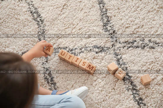 Little girl with autistic disorder playing with cubes at home. Стоковое фото, фотограф Pixel_shot / Фотобанк Лори
