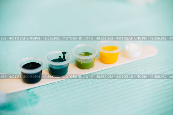 Little tattoo ink bottles full of different colors. Tattoo concept.. Little tattoo ink bottles full of different colors. Стоковое фото, агентство Ingram Publishing / Фотобанк Лори