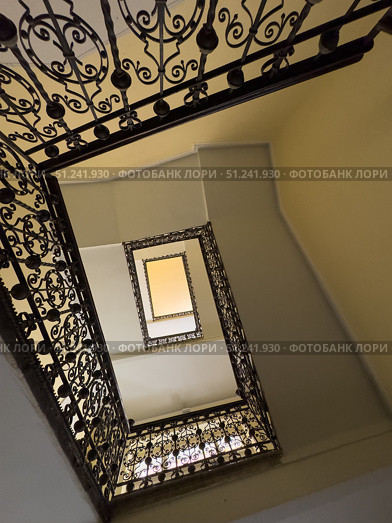 Looking upward through a decorative spiral staircase with elegant ironwork railings. Стоковое фото, фотограф Антон Гвоздиков / Фотобанк Лори