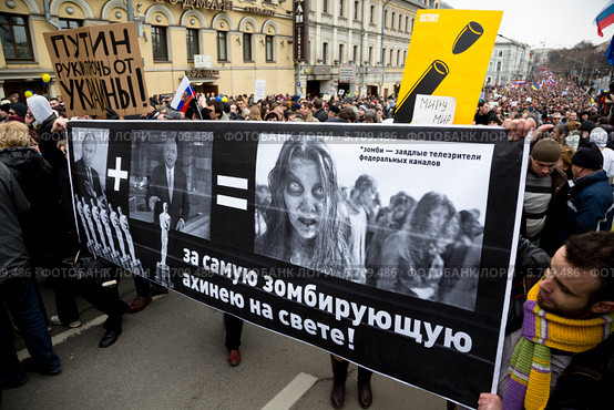 Люди держат плакат на "Марше мира" по Бульварному кольцу города Москвы в поддержку украинского народа и против военных действий 15 марта 2014. Редакционное фото, фотограф Николай Винокуров / Фотобанк Лори
