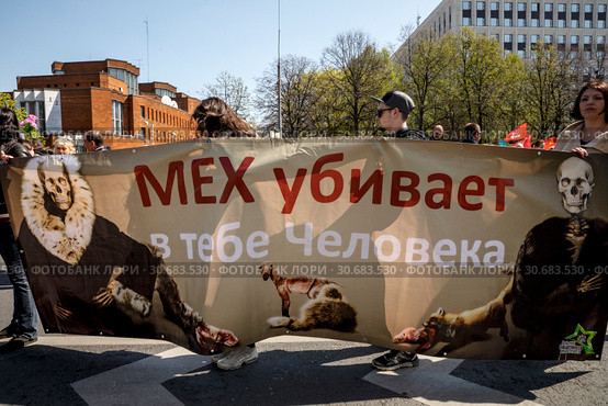 Люди держат плакат против использования меха животных на Первомайском марше в защиту животных по центральным улицам города Москвы, Россия (2019 год). Редакционное фото, фотограф Николай Винокуров / Фотобанк Лори