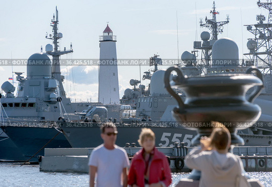 Люди фотографируются на Петровской пристани на фоне военных кораблей. Малый Кронштадтский рейд. Кронштадт. Санкт-Петербург (2021 год). Редакционное фото, фотограф Румянцева Наталия / Фотобанк Лори