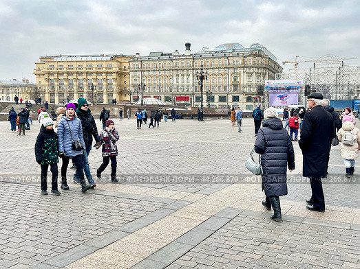 Люди гуляют по Манежной площади на фоне Моховой улицы в Москве. Редакционное фото, фотограф Овчинникова Ирина / Фотобанк Лори