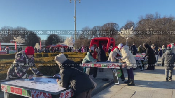 Люди играют в аэрохоккей в парке Горького Москвы на зимнем фестивале "Московские традиции" Редакционное видео, видеограф Анастасия / Фотобанк Лори
