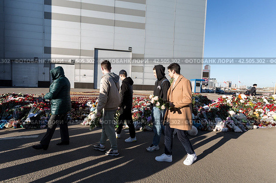 Люди несут цветы к стихийному мемориалу в память о погибших в результате теракта в Крокус Сити Холле. Красногорск, Московская область, Россия (2024 год). Редакционное фото, фотограф Наталья Волкова / Фотобанк Лори