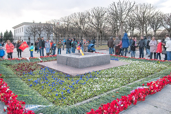 Люди в День Победы возле Вечного огня на Пискаревском мемориальном кладбище. Санкт-Петербург (2017 год). Редакционное фото, фотограф Румянцева Наталия / Фотобанк Лори
