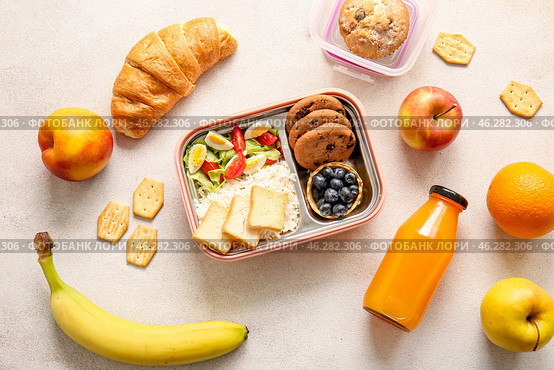 Lunchboxes with delicious food and bottle of juice on light background. Стоковое фото, фотограф Pixel_shot / Фотобанк Лори