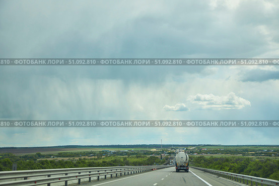 M4 Highway Russia - May 10, 2022: Road section and rain clouds ahead. Редакционное фото, фотограф Наталия Кирсанова / Фотобанк Лори