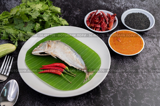 Mackerel paste and chilies on banana leaves on a white plate, complete with liquid and vegetables. Стоковое фото, агентство Ingram Publishing / Фотобанк Лори