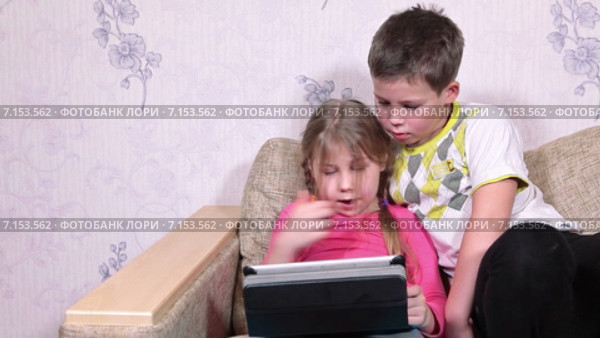 Мальчик и девочка увлечены игрой на планшете. Стоковое видео, видеограф Кекяляйнен Андрей / Фотобанк Лори