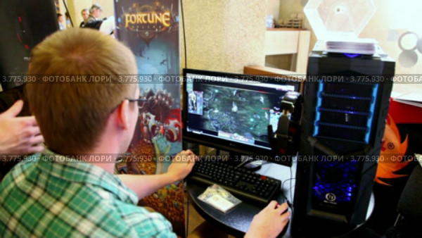 Мальчик сидит за компьютером и играет в игру во время  Конференции разработчиков игр 2011 (2012 год). Редакционное видео, видеограф Losevsky Pavel / Фотобанк Лори