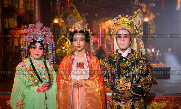 Male and female Chinese opera actors Light a candle to pray homage to the gods to enhance the prosperity for yourself on the occasion of the Chinese New Year festival. Стоковое фото, агентство Ingram Publishing / Фотобанк Лори