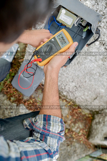 male electrician using a voltmeter. Стоковое фото, агентство Ingram Publishing / Фотобанк Лори