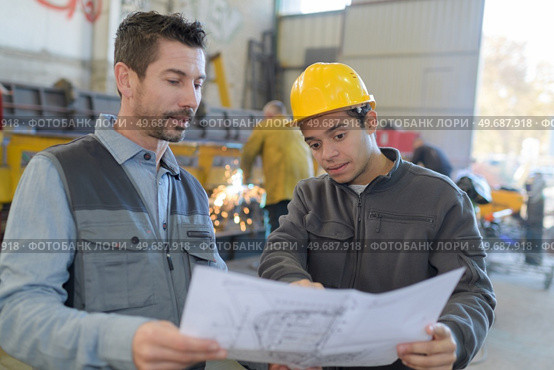 male factory worker and supervisor are analyzing plans. Стоковое фото, агентство Ingram Publishing / Фотобанк Лори