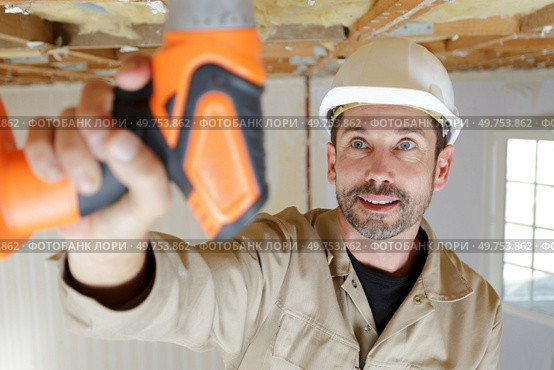 male holds a drill indoors. Стоковое фото, агентство Ingram Publishing / Фотобанк Лори