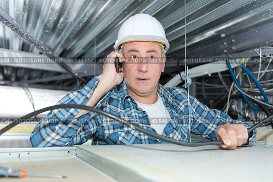 male insulation installer on phone. Стоковое фото, агентство Ingram Publishing / Фотобанк Лори