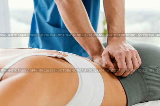 male osteopathic therapist checking female patient s lower back spine. Beautiful photo. male osteopathic therapist checking female patient s lower back spine. Стоковое фото, агентство Ingram Publishing / Фотобанк Лори