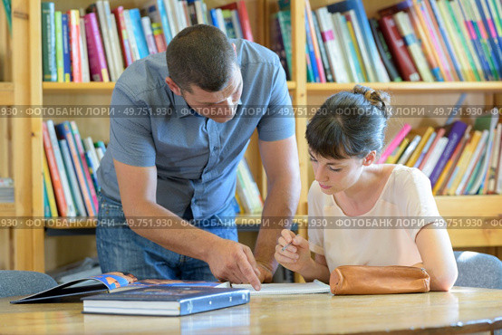male teacher working with college student in library. Стоковое фото, агентство Ingram Publishing / Фотобанк Лори