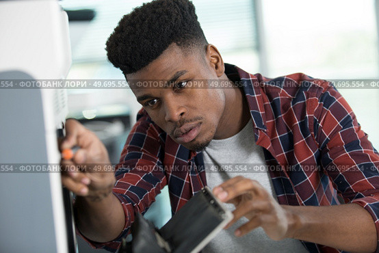 male technician servicing a photocopier. Стоковое фото, агентство Ingram Publishing / Фотобанк Лори