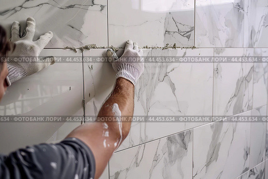 Male Worker Master Laying Ceramic Tiles on the Wall of Kitchen. Repairman Placing White Marble Modern Tiles, Spreading Adhesive. Builder Installing Tile at Repair Renovation Work. Professional Tiling. Стоковое AI-изображение, AI-художник Марина Демидюк / Фотобанк Лори