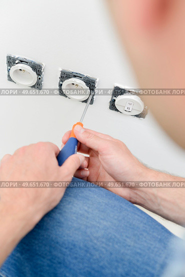 male worker replacing electrical socket. Стоковое фото, агентство Ingram Publishing / Фотобанк Лори