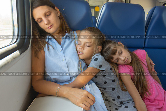 Мама и две дочки уснули в вагоне электропоезда. Стоковое фото, фотограф Иванов Алексей / Фотобанк Лори