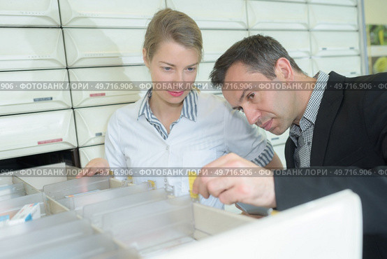 Man and pharmacist looking into drawer. Стоковое фото, агентство Ingram Publishing / Фотобанк Лори