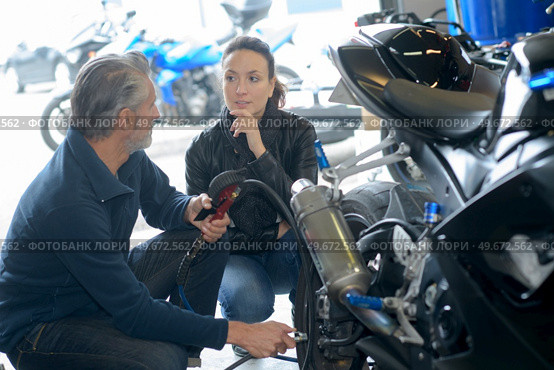 man and woman checking motorbike in workshop. Стоковое фото, агентство Ingram Publishing / Фотобанк Лори