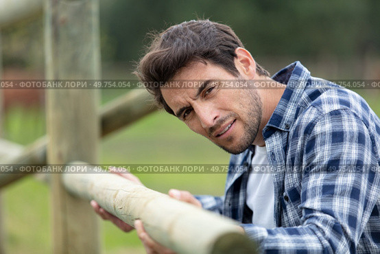man assembling wood fence in a ranch. Стоковое фото, агентство Ingram Publishing / Фотобанк Лори