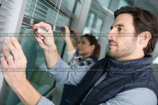 man attaching elements with a screwdriver. Стоковое фото, агентство Ingram Publishing / Фотобанк Лори