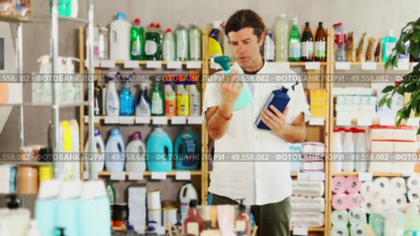 Man buyer shoose kitchen cleaner spray in household store. Стоковое видео, видеограф Яков Филимонов / Фотобанк Лори