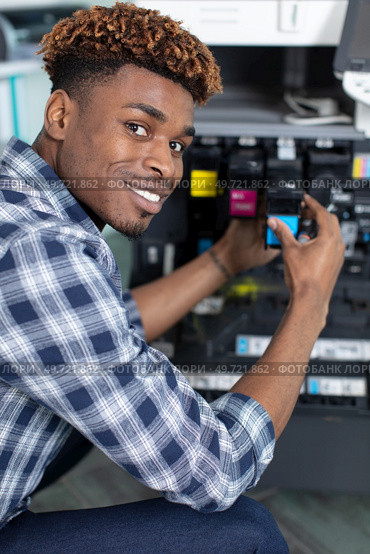 man changing cartridge in color printer. Стоковое фото, агентство Ingram Publishing / Фотобанк Лори