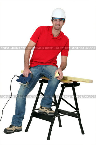 Man cutting a piece of wood with a jigsaw. Стоковое фото, агентство Ingram Publishing / Фотобанк Лори