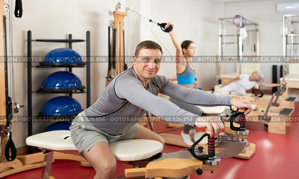 Man during Pilates training performs exercises and tasks on heron pulley tower. Стоковое фото, фотограф Яков Филимонов / Фотобанк Лори