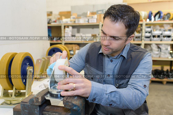 man fixing wheels of shopping cart. Стоковое фото, агентство Ingram Publishing / Фотобанк Лори