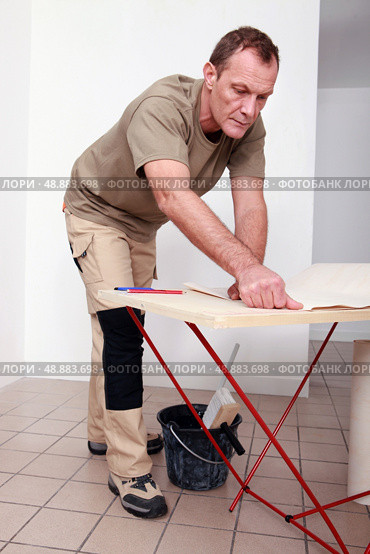 Man gluing paper together. Стоковое фото, агентство Ingram Publishing / Фотобанк Лори